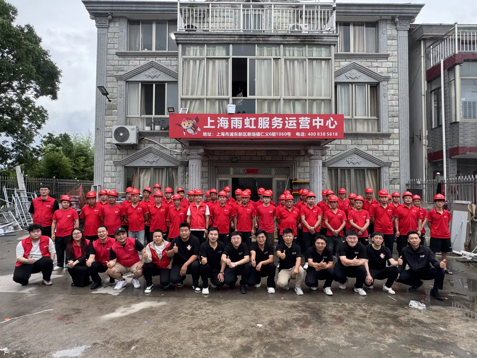 齐泰众成提供的服务团队合影，队员身着红色工作服在培训中心前合照